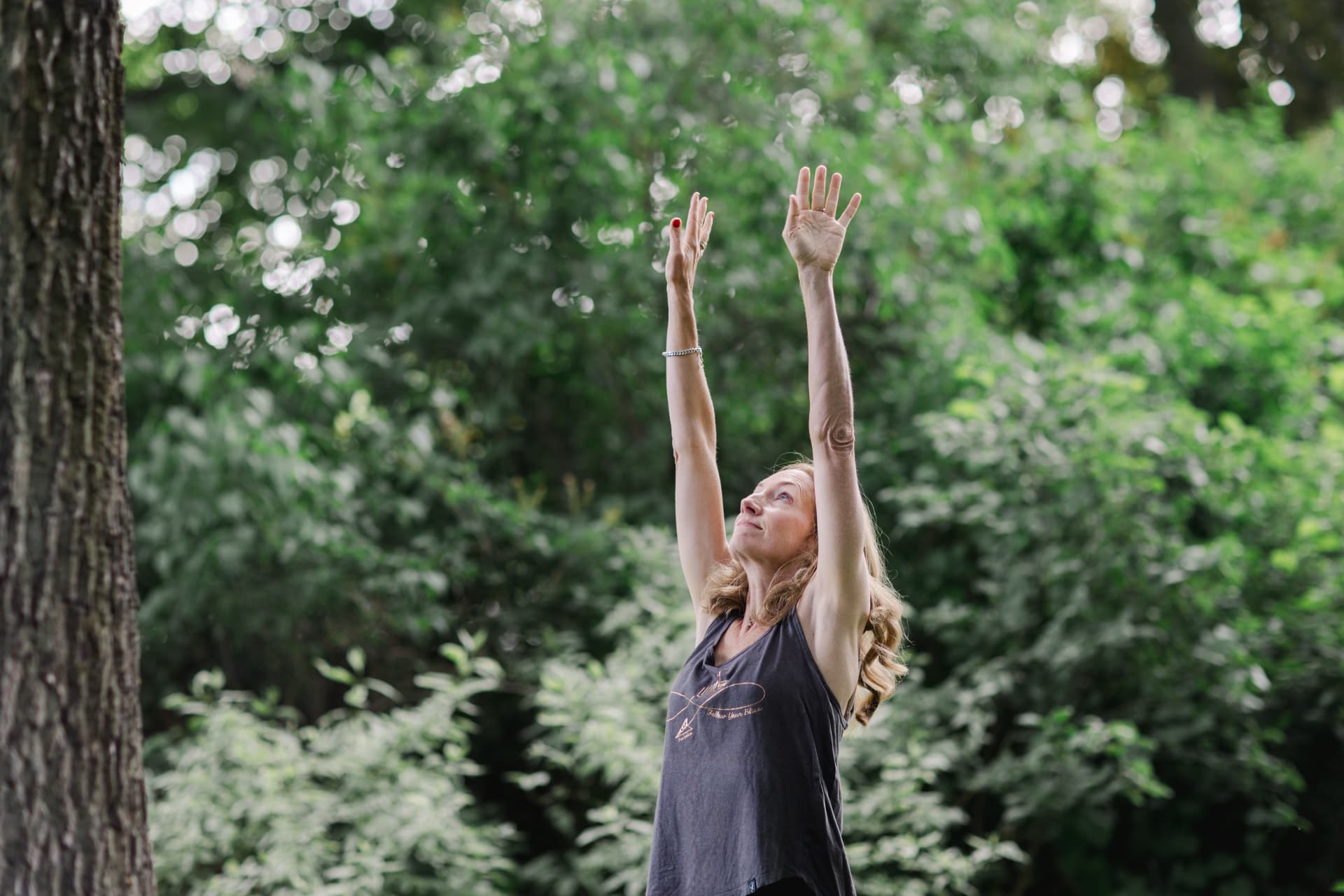 Pia’s raised hands and face in the forest